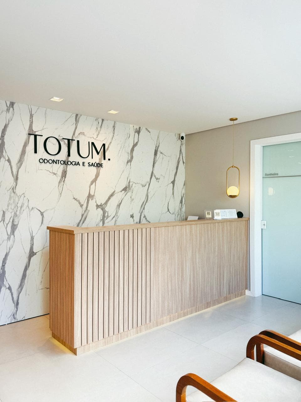 Balcão de recepção da Totum com parede de mármore